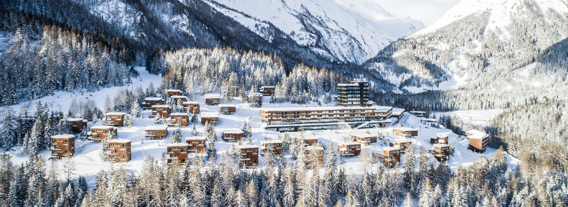 Das Bild zeigt eine Hotelanlage in einer verschneiten Landschaft.