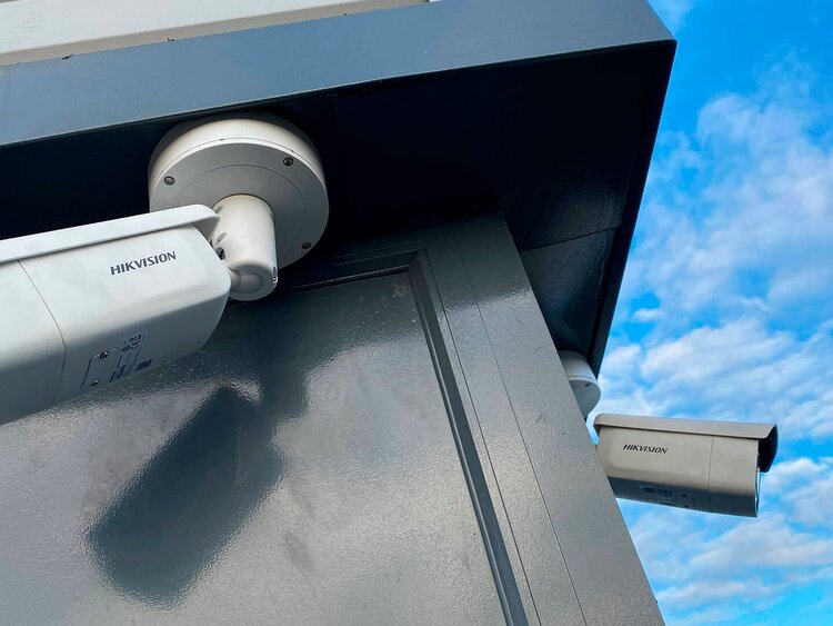 Das Bild zeigt zwei HIKVISION-Kameras im Außenbereich. 