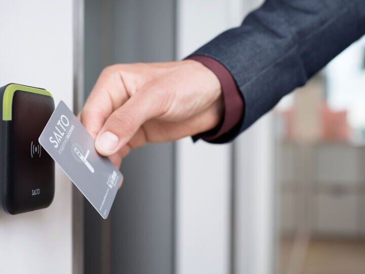 Das Bild zeigt die Verwendung einer RFID-Karte bei einer Tür, die mit einer Salto-Zutrittskontrolle bestückt ist.