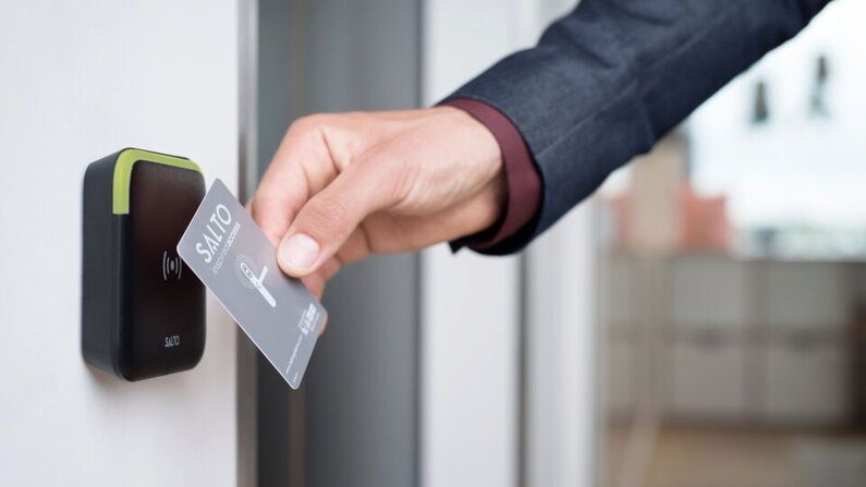 Das Bild zeigt die Verwendung einer RFID-Karte bei einer Tür, die mit einer Salto-Zutrittskontrolle bestückt ist.