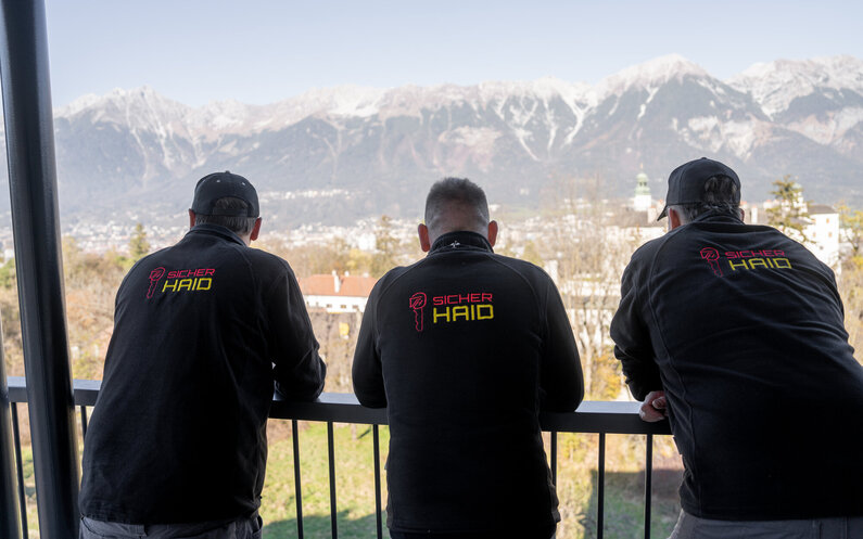 Ein Bild, das 3 Mitarbeiter beim Arbeiten zeigt.