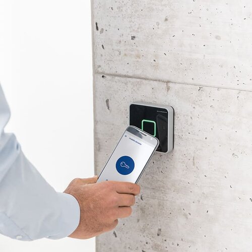 Ein Bild, dass die Verwendung eines Handys zum eintreten bei einer Zutrittskontrolle darstellt