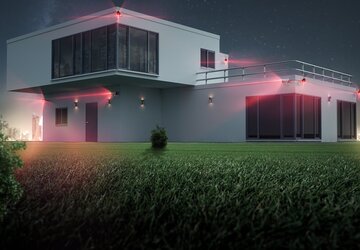 Das Bild zeigt ein Haus, dass mit verschiedenen Modulen einer Alarmanlage ausgestattet ist. 